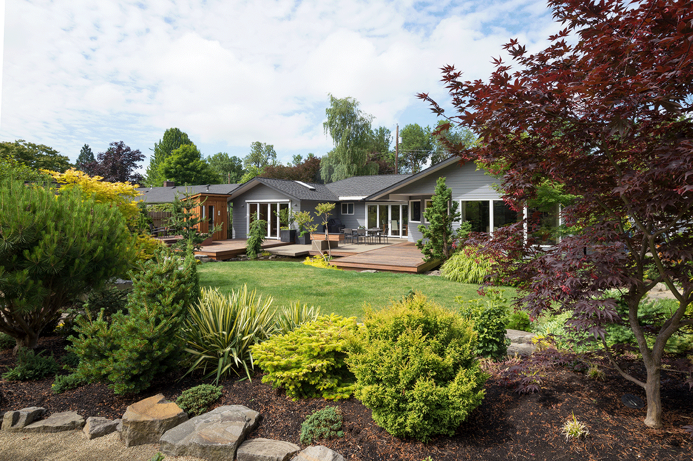 Концепция уютного сада с деревянной террасой и зеленью